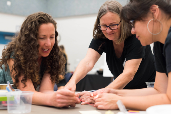 Three educators are collaborating at a table